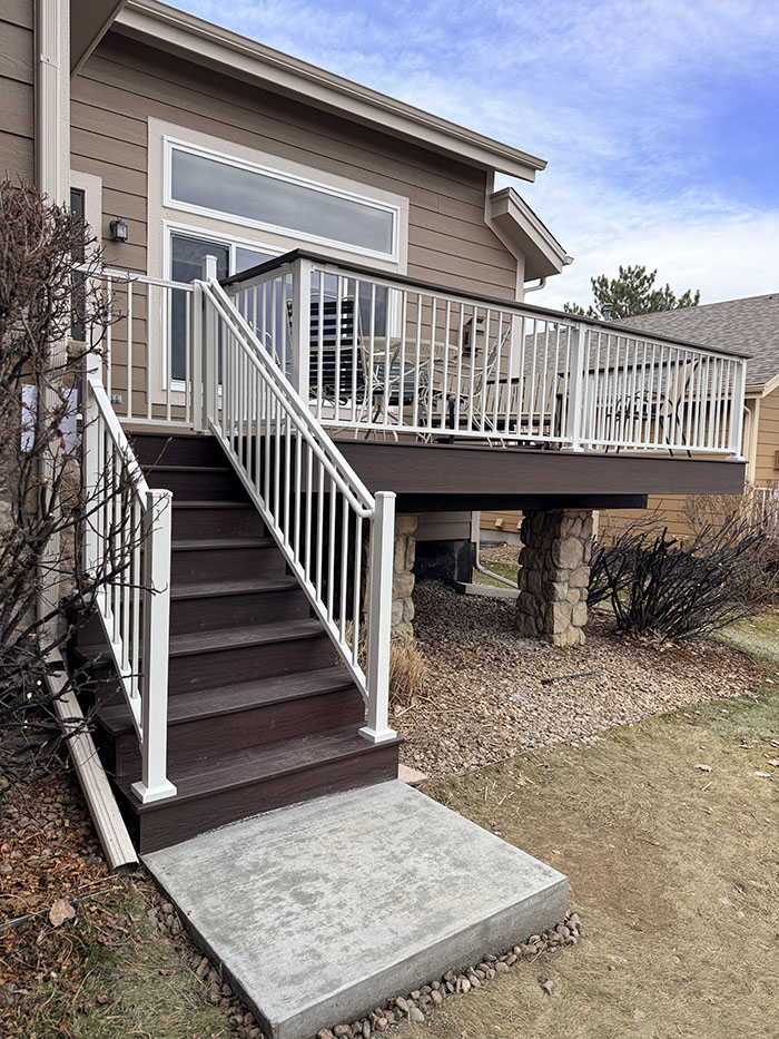 Front entry into a beautiful Trex® outdoor living space with Newcastle steel framing and Trex® Signature® white railing in Littleton, CO.